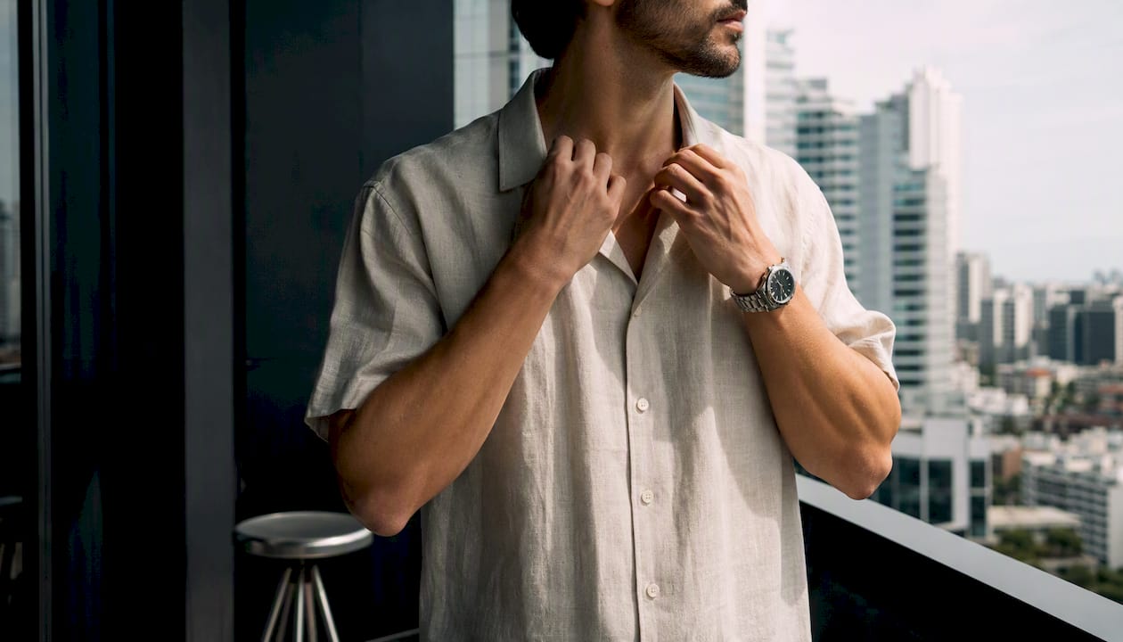 Man adjusting linen camp collar shirt