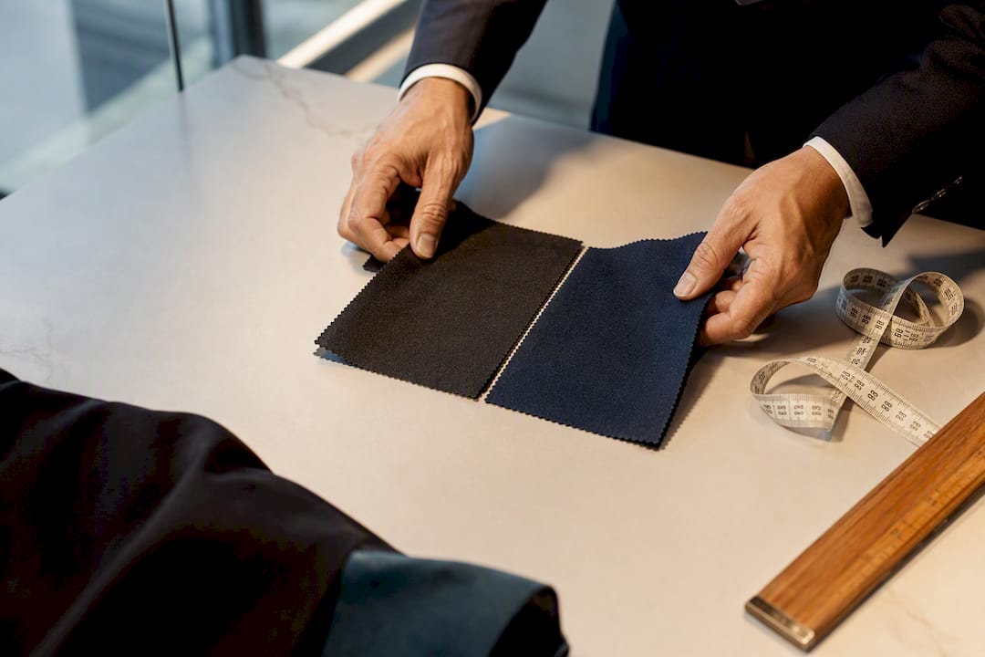 Tailor comparing wedding suit fabric swatches
