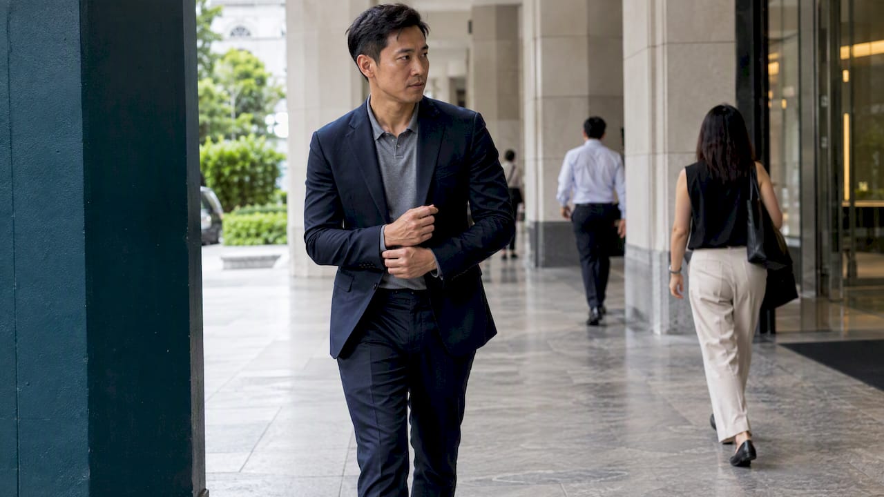 Man wearing a knit polo with navy suit