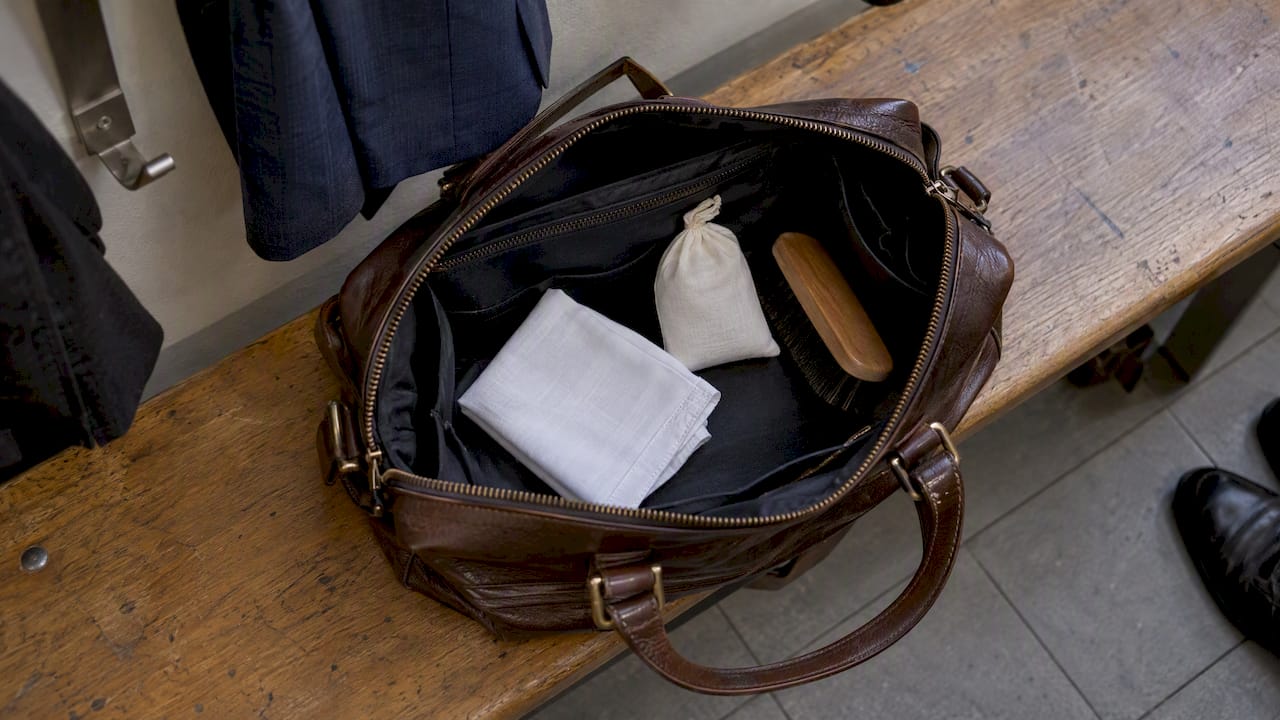 Handkerchief, talc sachet, and brush in a work bag