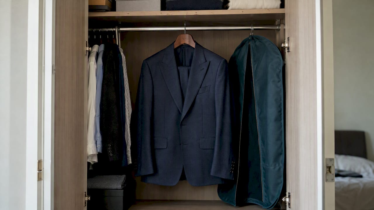 Bespoke suit hanging in a wardrobe