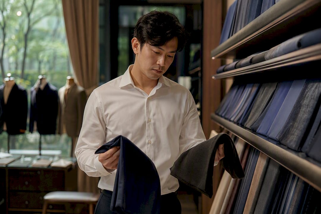新郎在挑选深蓝色和炭灰色西服面料