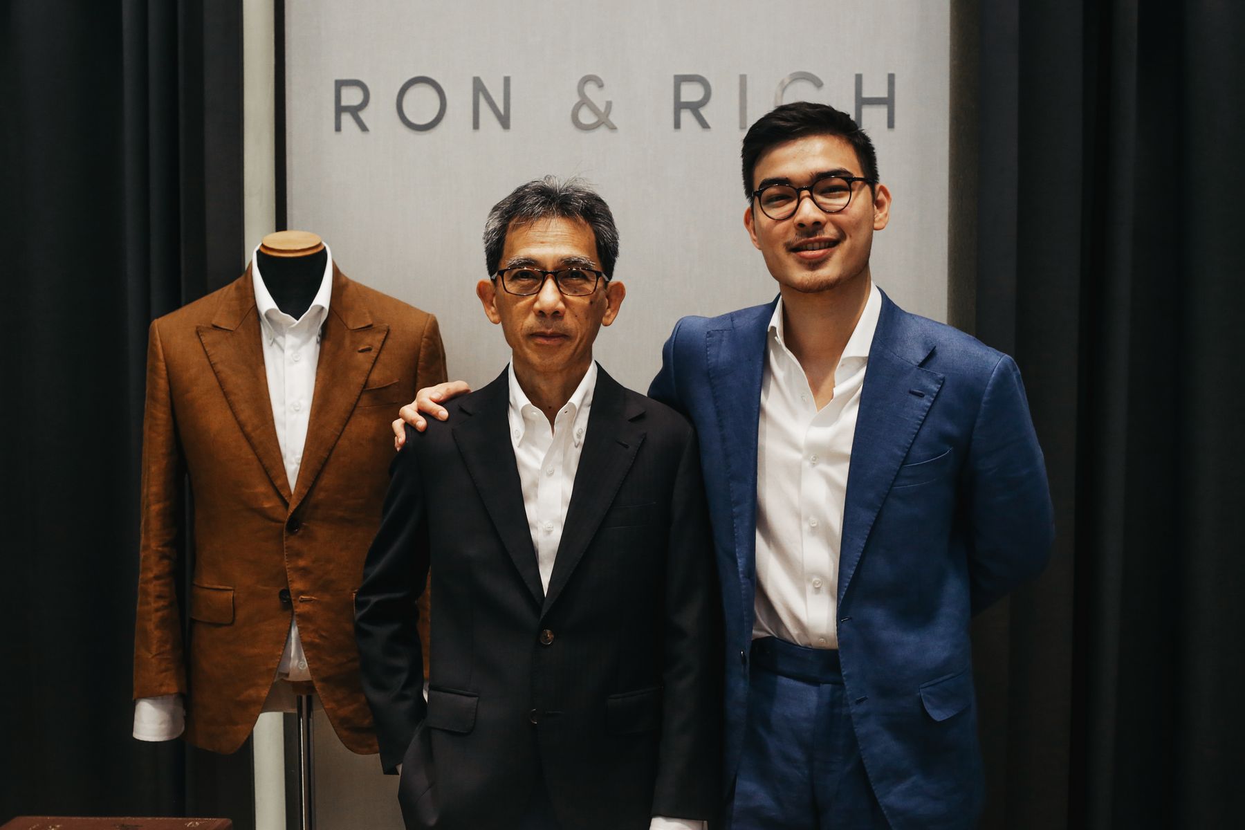 Richard and Aaron Fan beneath the Ron & Rich sign