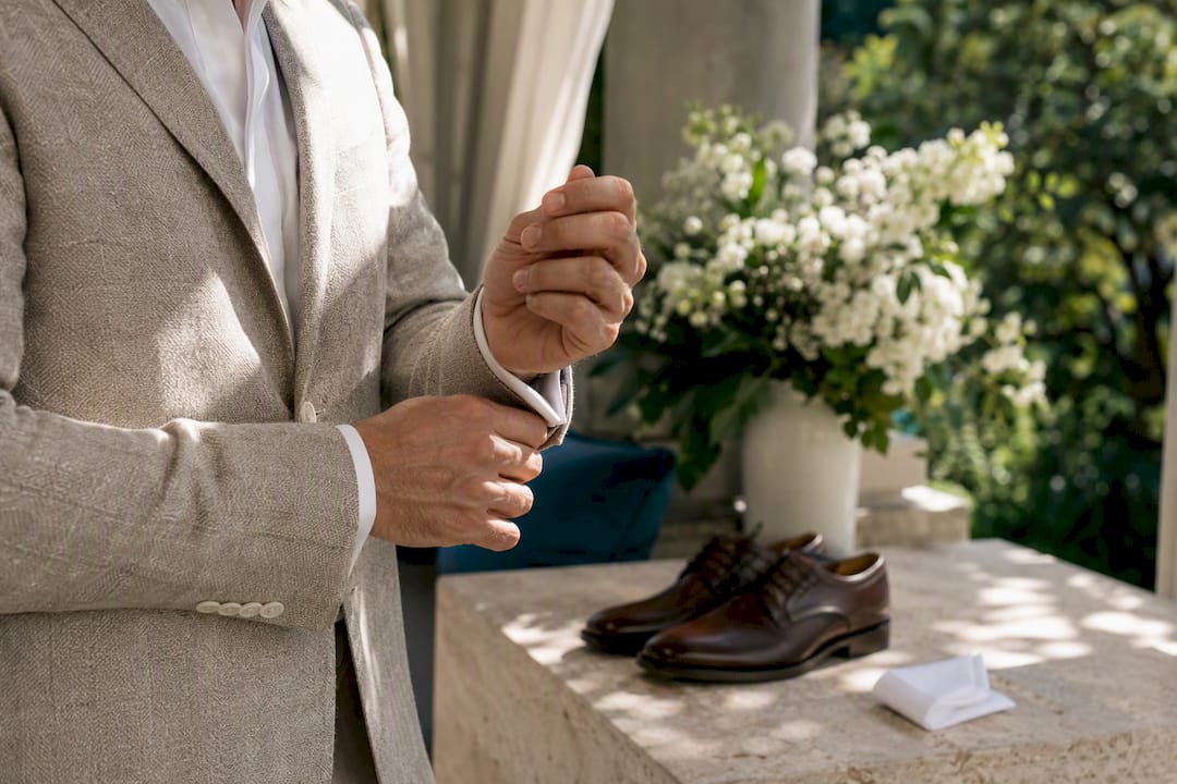 Man adjusting linen jacket sleeve outdoors