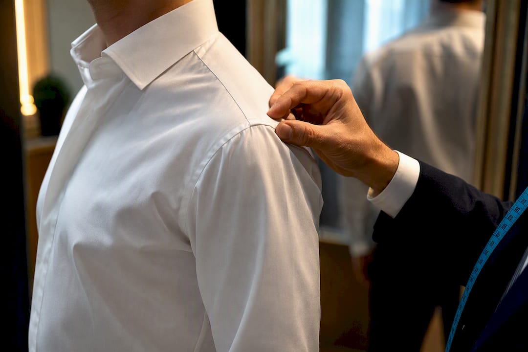 Tailor checking a shirt shoulder seam